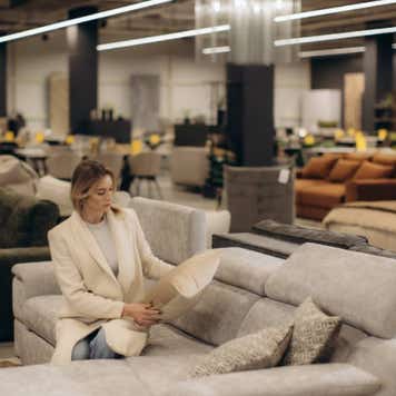 Woman Shopping for Sofas in Modern Furniture Store Interior