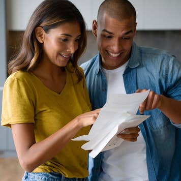 Excited Latin American couple looking at a letter.