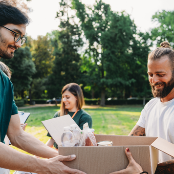 A couple takes a donation box to the food and clothes bank.