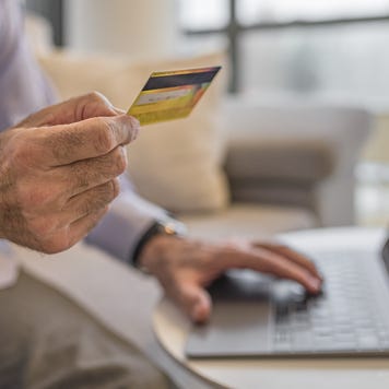 An older man holding a credit card