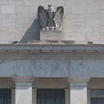 Close-up photo of the front of the Federal Reserve in Washington, DC, with the name "Federal Reserve" below the bust of the eagle.