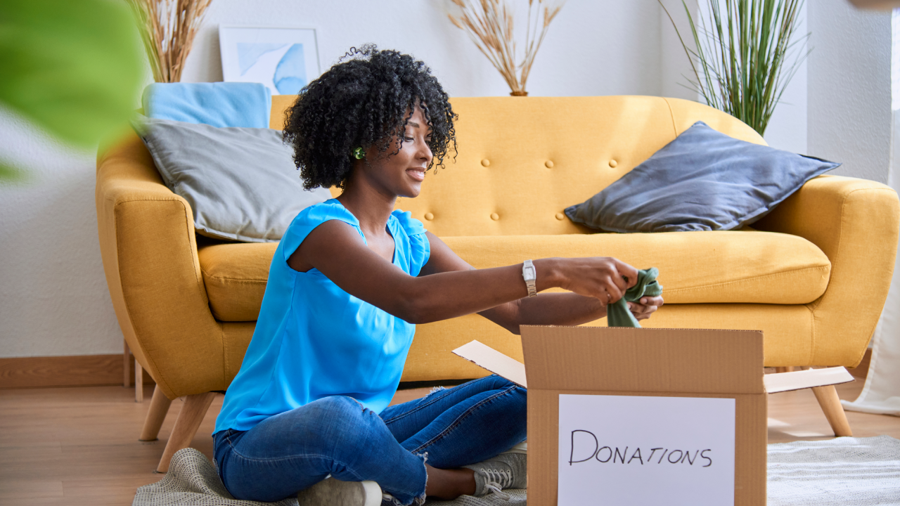 Woman packing and sorting clothes to donate.