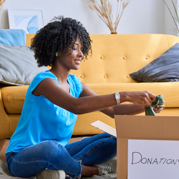 Woman packing and sorting clothes to donate.