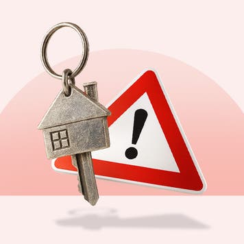 Key in the shape of a house over a triangular warning sign with an exclamation point all over a light red background