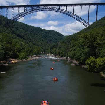 A large bridge over a body of water with boaters.