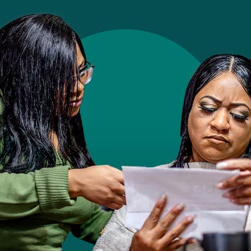 two women looking at an envelope, concerned