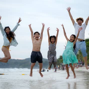 Asian Family Jumping at the beach