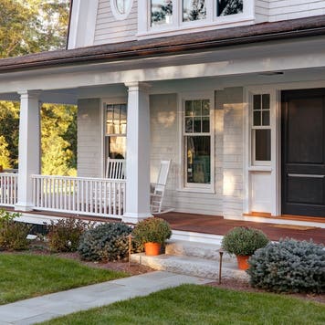 Classic style new home exterior view with front porch and front door entrance.