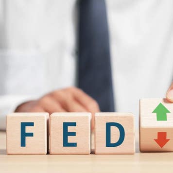 Fed rate hike to curb inflation, wooden block with FED and up-down arrows icon. Central banking system and interest rate changes.