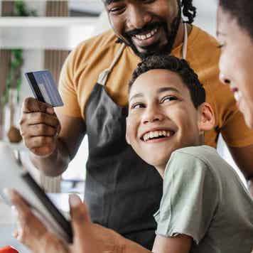Young boy and his parents are in the kitchen ordering groceries