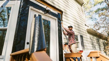 Person repairing home siding