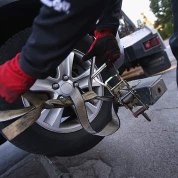 Recovery agent or 'repo man' Jeff Grevelding secures a car for towing while repossessing cars on October 11, 2012 in Syracuse, New York. Grevelding, who works for Advanced Recovery of New York, works with fellow agents day and night locating and towing vehicles legally repossessed by banks and loan agencies, after the owners stop making payments.