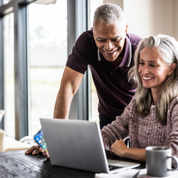 Older couple using a laptop at home.