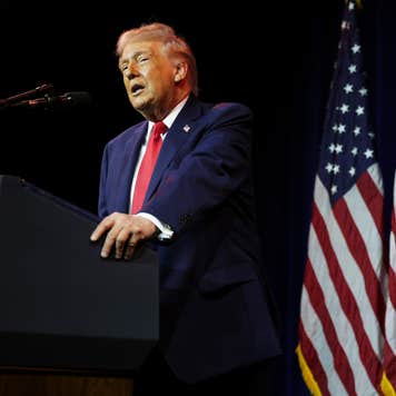 President Donald Trump speaks behind a podim with a U.S. flag in the background