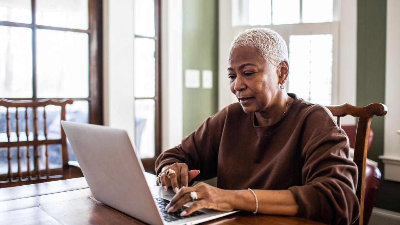 Older woman doing her taxes on her laptop at home.