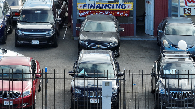 A used car lot promotes easy financing in its storefront.