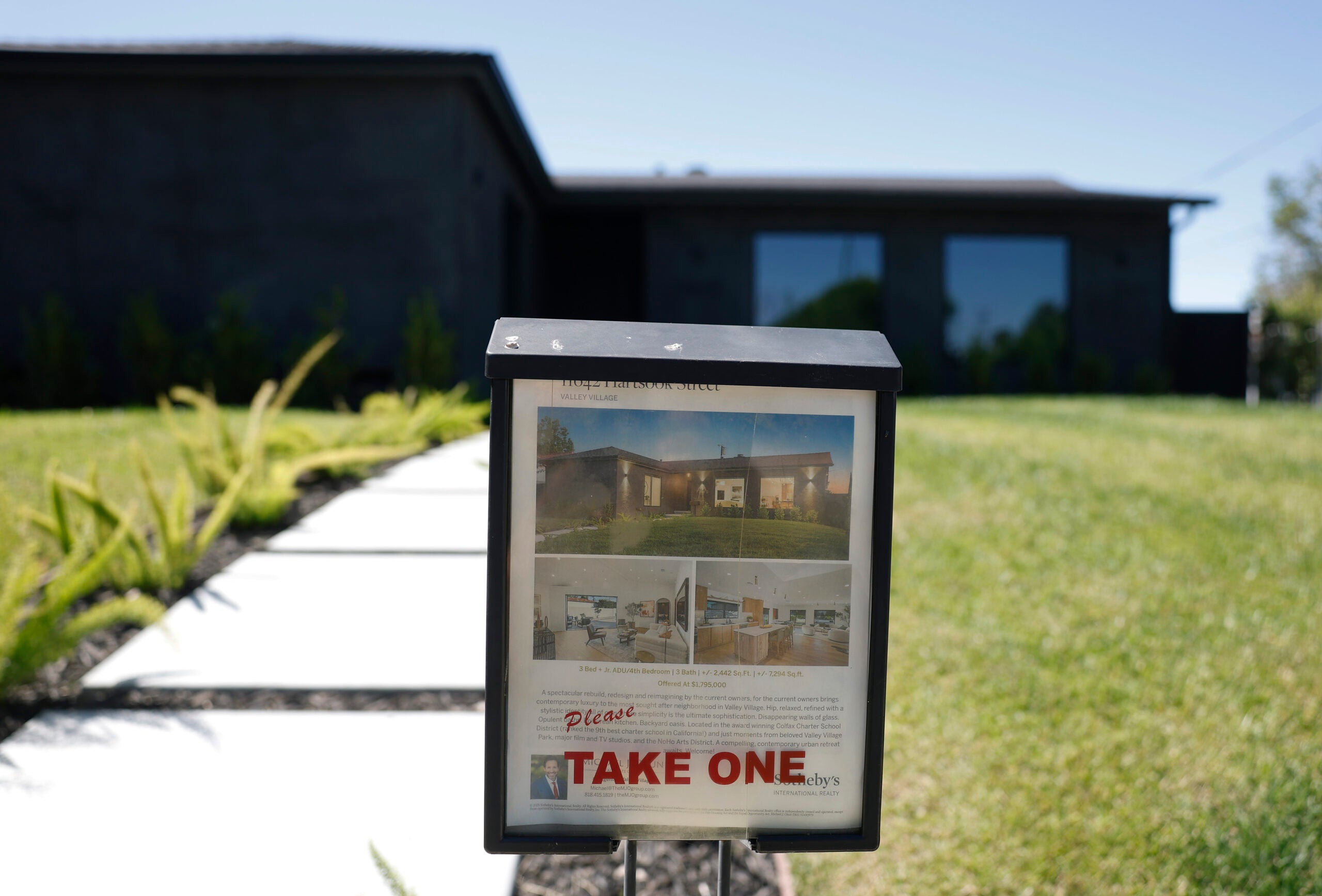 A "Pleast take one" sign in front of a for-sale property.