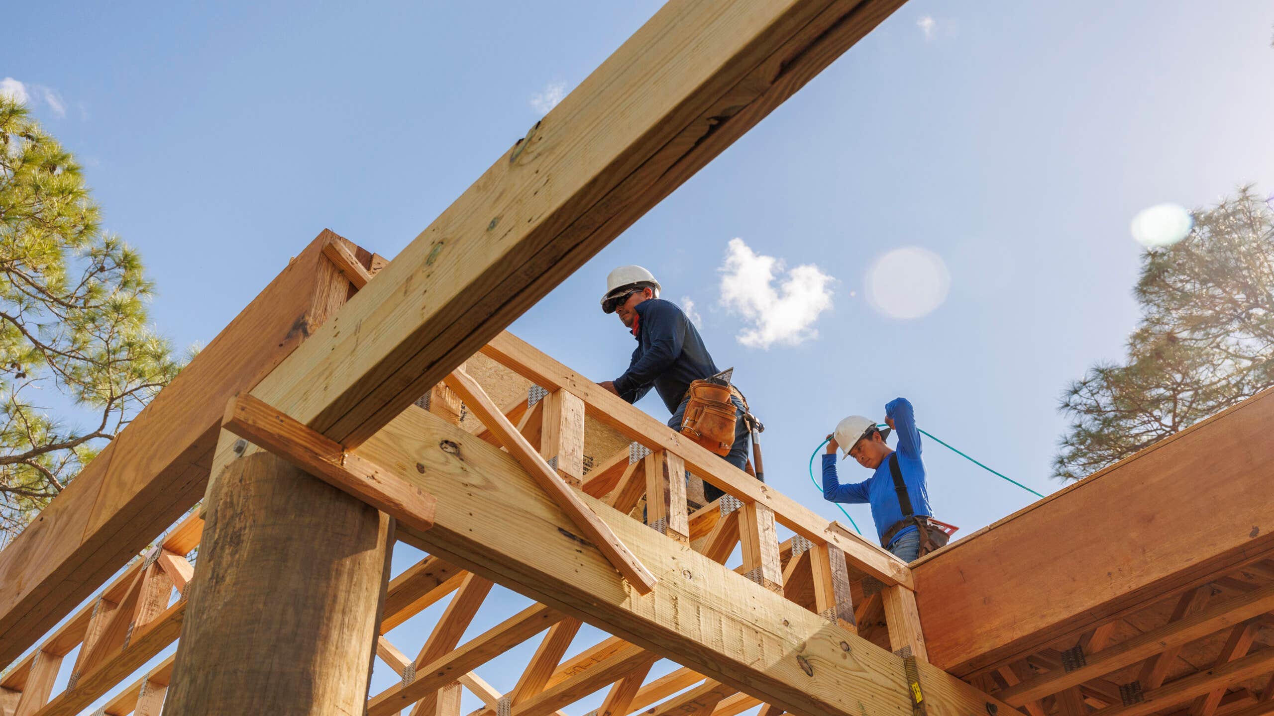 A cosntruction worker stands on the top of an under-construction structure