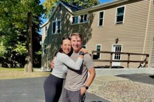 Ali and Josh Lupo in front of one of their homes.