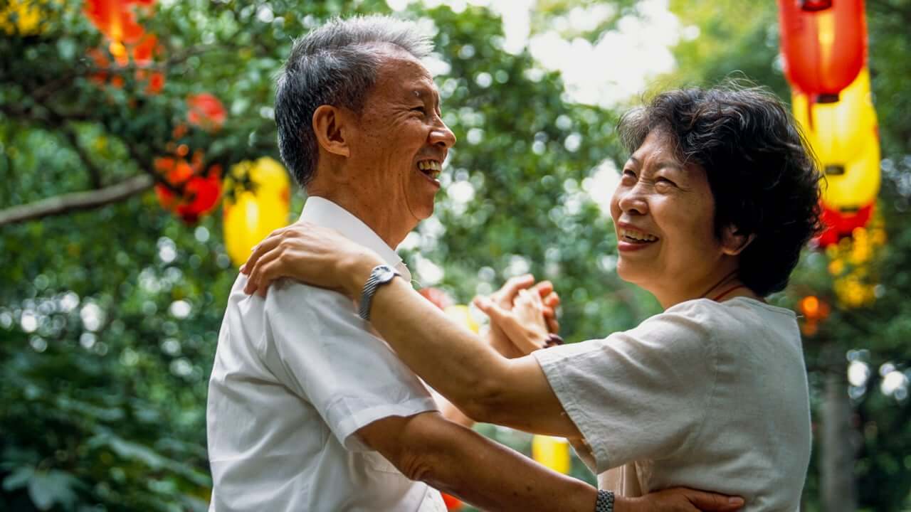 a senior couple dancing outdoors