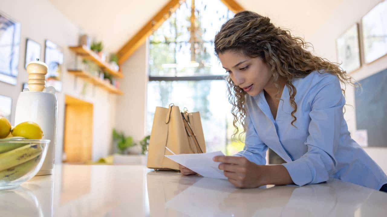 Woman reading a letter in the mail after arriving home