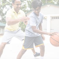 Boy and father play basketball