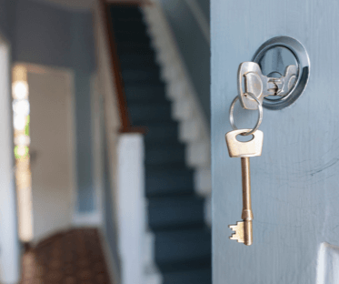 Open house door with key in lock