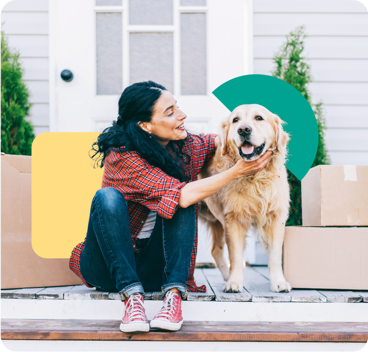 A woman sitting in front of a door, petting her dog