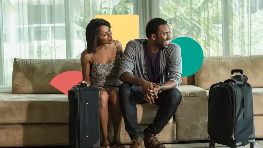 Couple sitting on couch with luggage