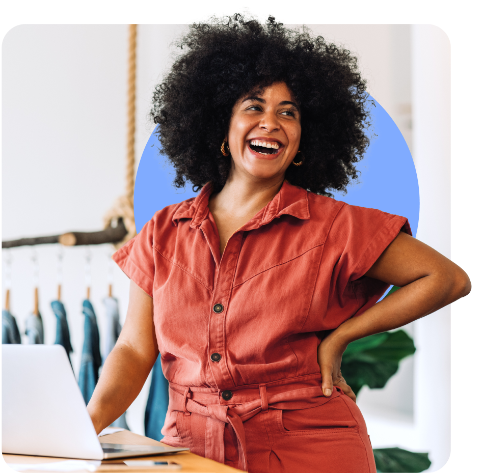 Smiling woman standing in front of a laptop